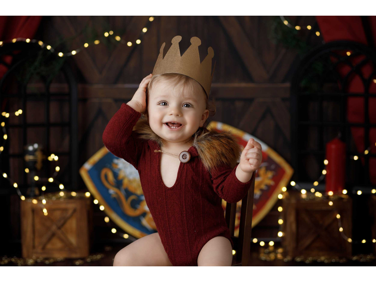 Fond photo bébé et smash cake Chevalier – décor chevalier avec boucliers, épée et rideaux rouges | Colors&Drops