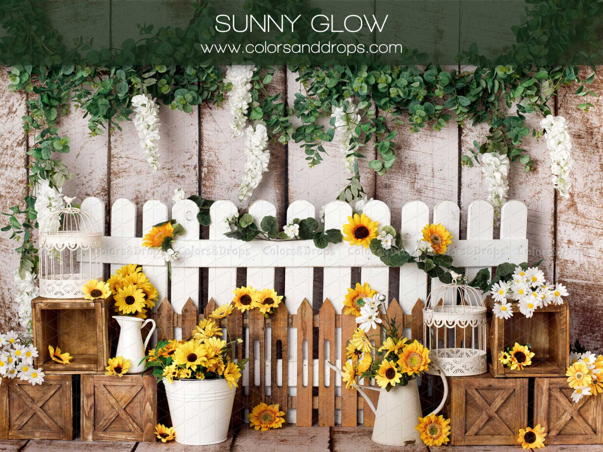 Fond photo bébé et smash cake Sunny Glow – clôture blanche avec tournesols, glycine et caisses en bois | Colors&Drops