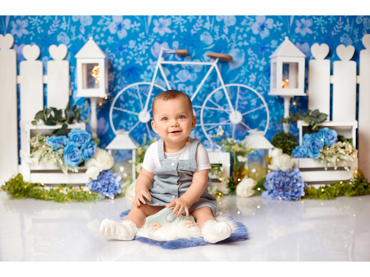 Fondo fotográfico de bebé y smash cake A Bicyclette – papel pintado floral azul con bicicleta y valla blanca | Colors&Drops