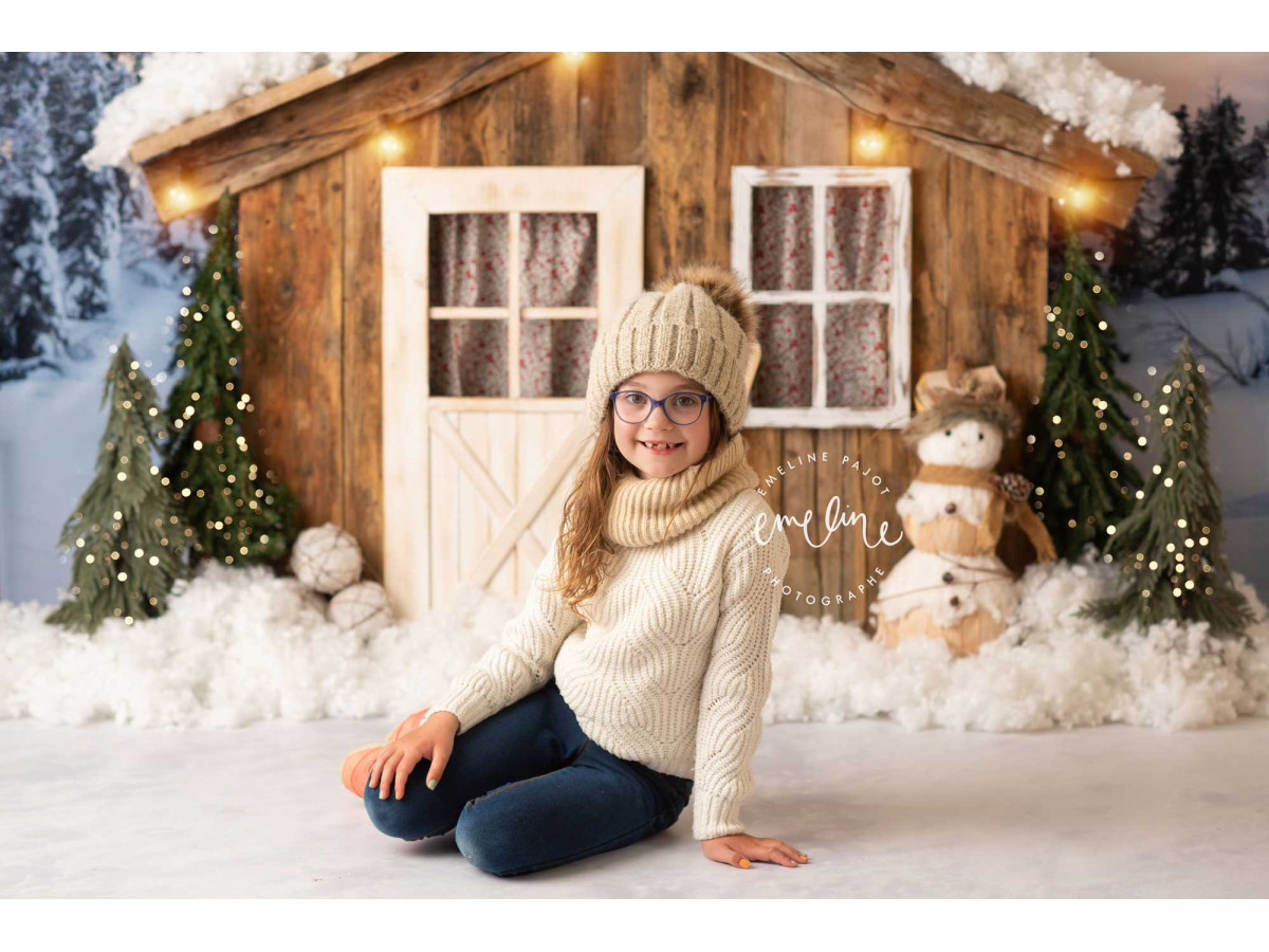 Fond photo de Noël Chalet des Neiges – chalet en bois enneigé avec bonhomme de neige et skis | Colors&Drops