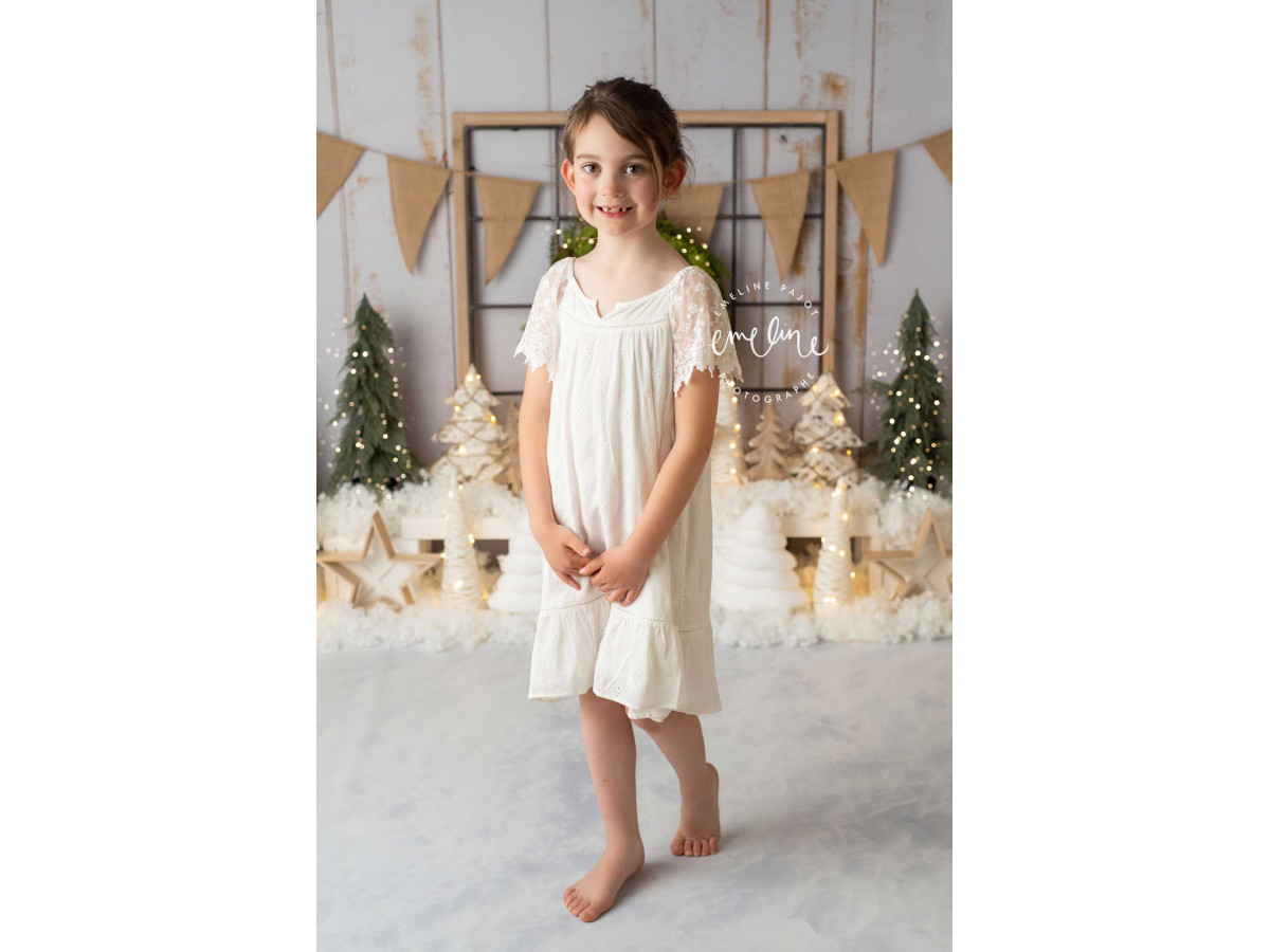 Fond photo de Noël Festif – mur en bois blanc avec couronne, fanions et petits sapins | Colors&Drops