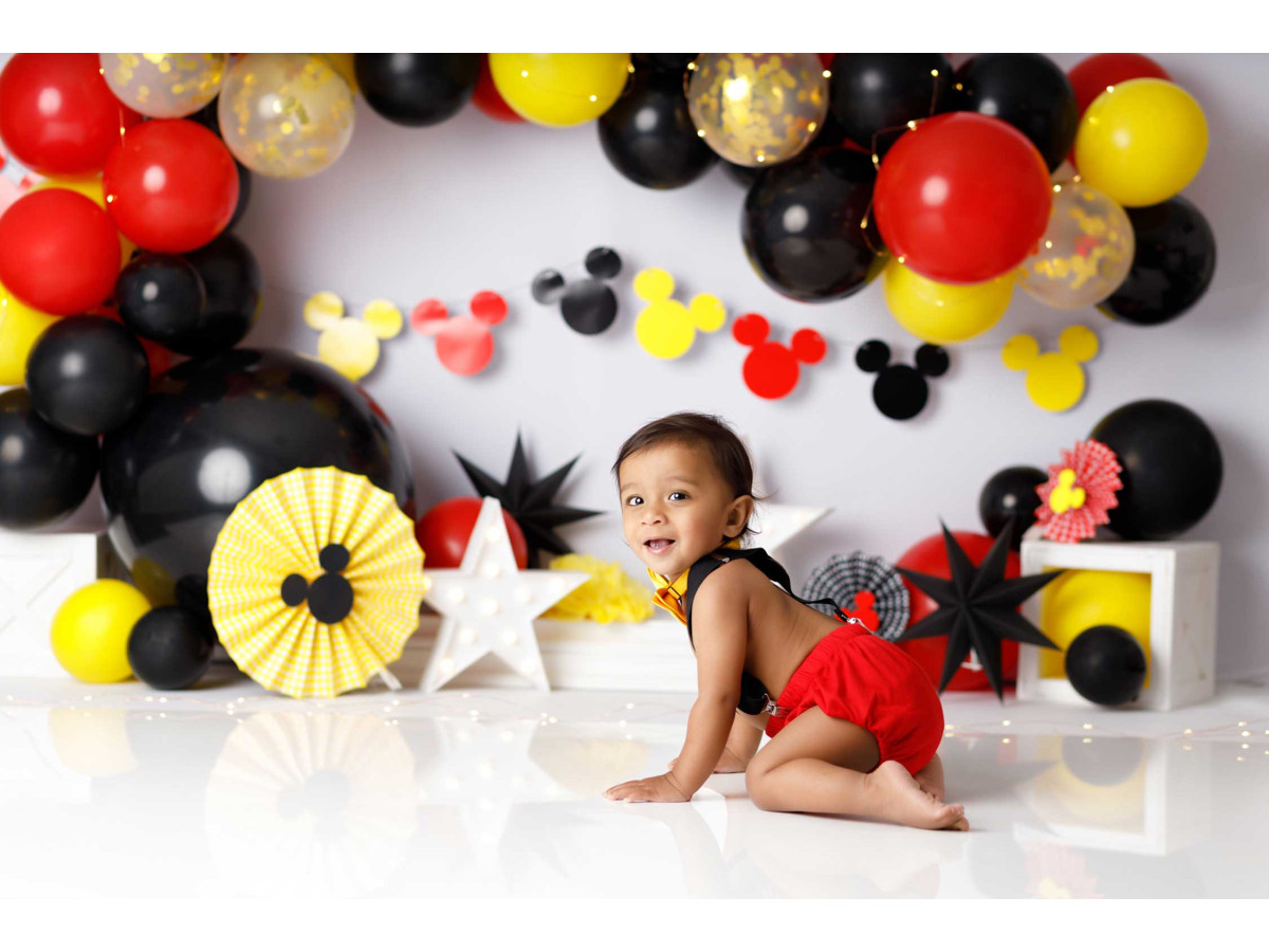 Fond photo bébé et smash cake Micky – arche de ballons rouges, noirs et jaunes avec rosaces | Colors&Drops