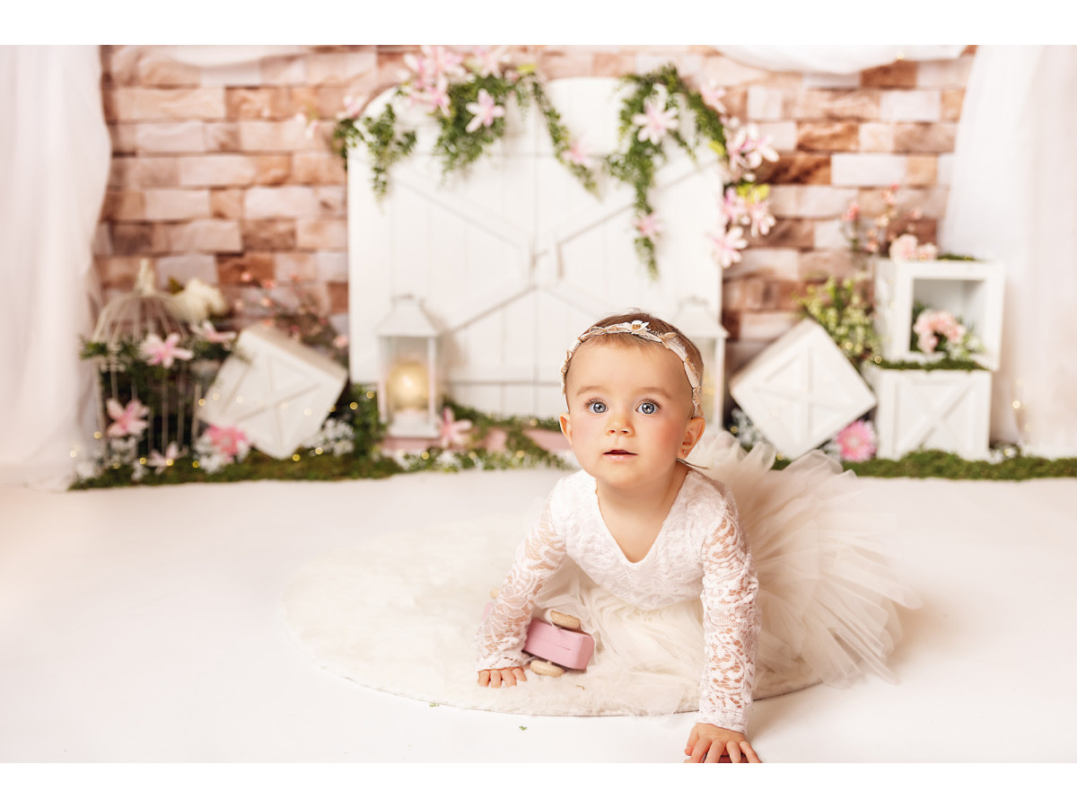 Fond photo bébé et smash cake Springy – porte de grange blanche sur mur en brique avec drapé | Colors&Drops