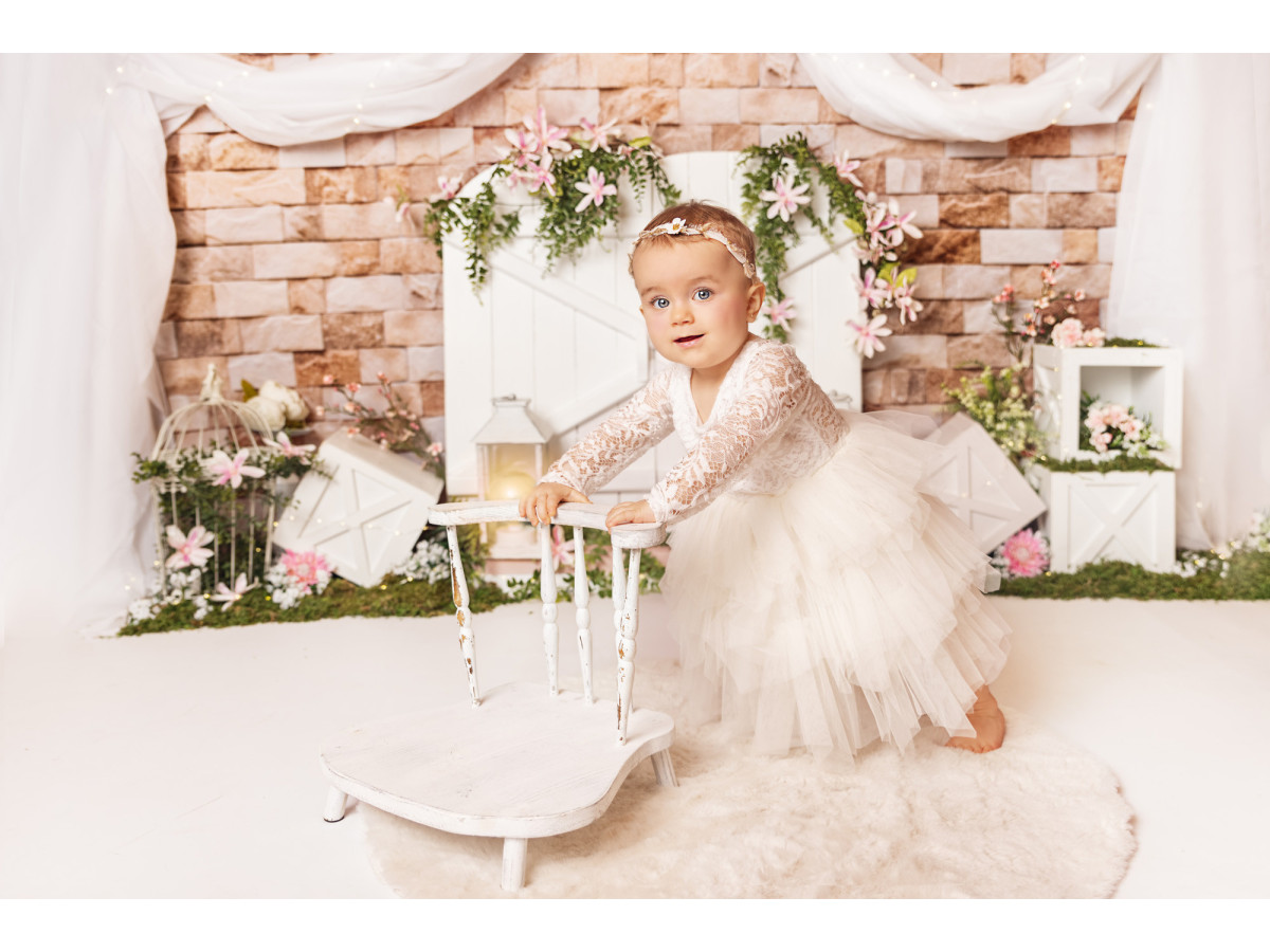 Fond photo bébé et smash cake Springy – porte de grange blanche sur mur en brique avec drapé | Colors&Drops