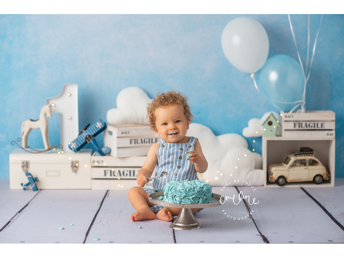 Fond photo bébé et smash cake Leon II – mur bleu avec ballons, nuages et caisses fragile | Colors&Drops