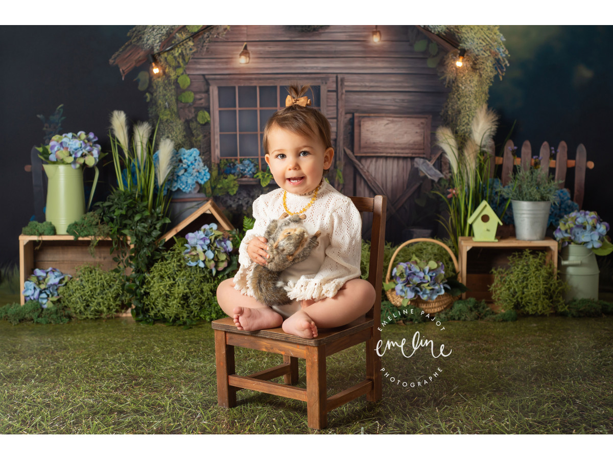 Fondo fotográfico de bebé y smash cake La Cabana – cabaña de madera con guirnalda de luces e hortensias | Colors&Drops