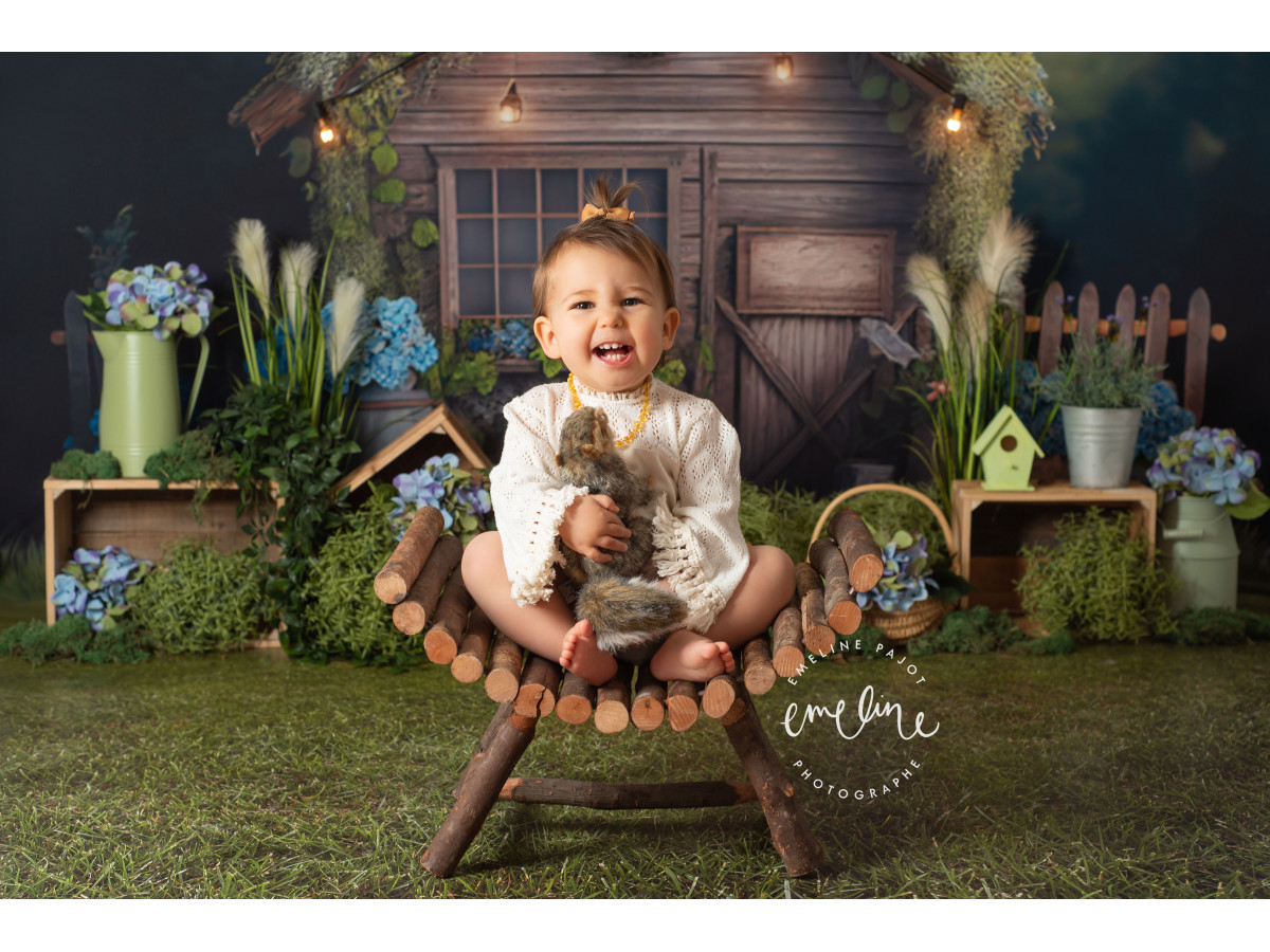 Fondo fotográfico de bebé y smash cake La Cabana – cabaña de madera con guirnalda de luces e hortensias | Colors&Drops