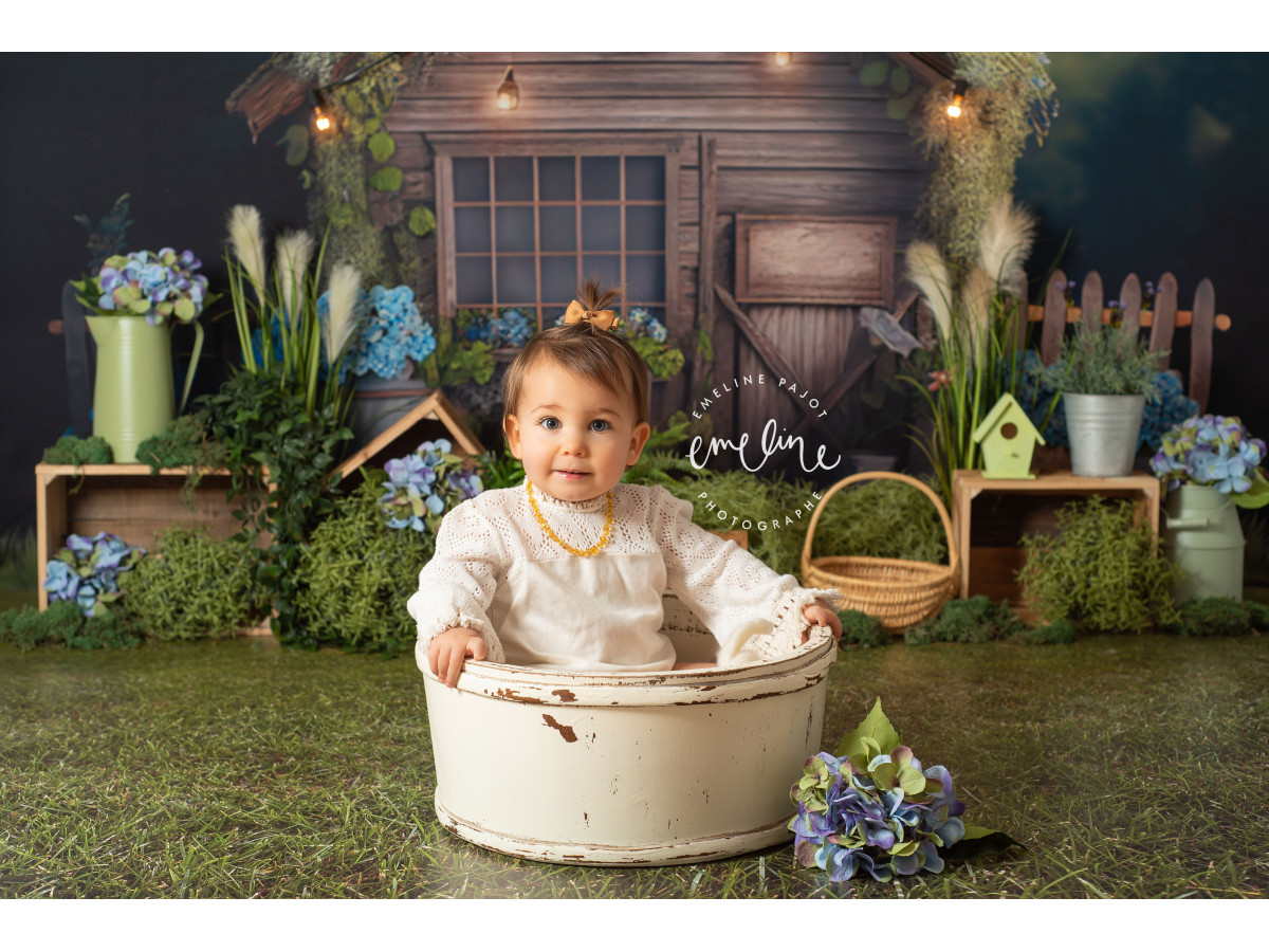 Fondo fotográfico de bebé y smash cake La Cabana – cabaña de madera con guirnalda de luces e hortensias | Colors&Drops