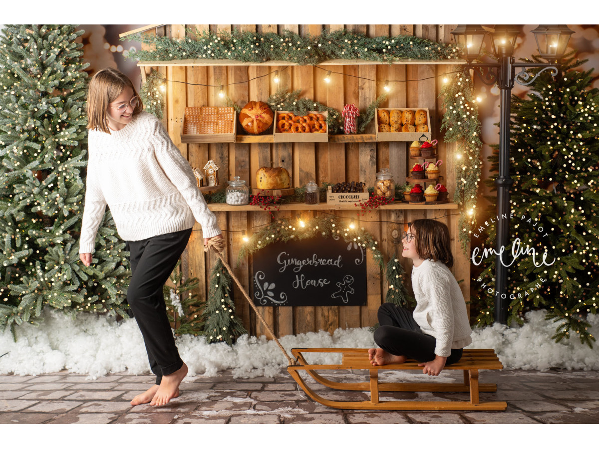 Fondo fotográfico de Navidad Gingerbread House – puesto de jengibre de madera entre abetos nevados | Colors&Drops