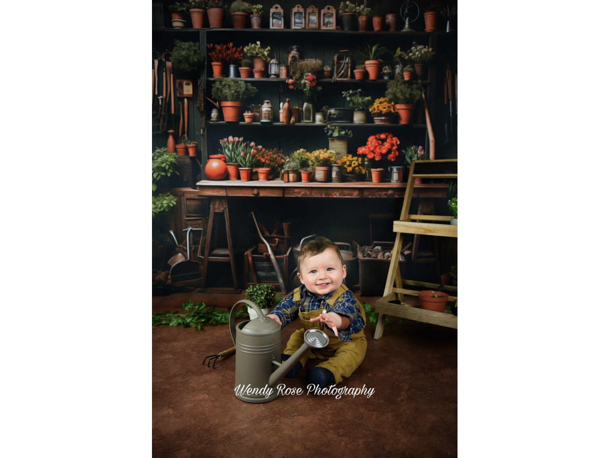 Fond photo de printemps L'Atelier Bota Brown – atelier de jardinier avec outils, pots et fleurs rouges | Colors&Drops